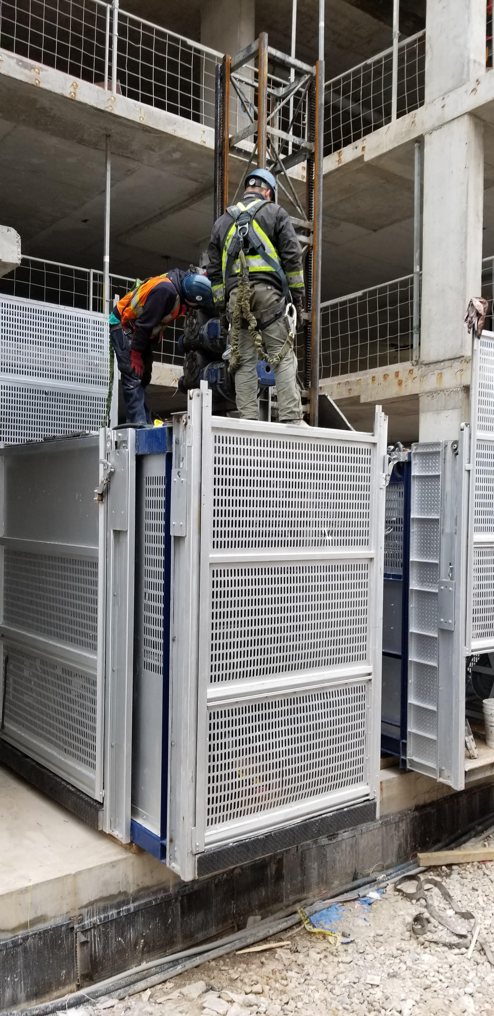 Certified mechanics maintaining a hoist.